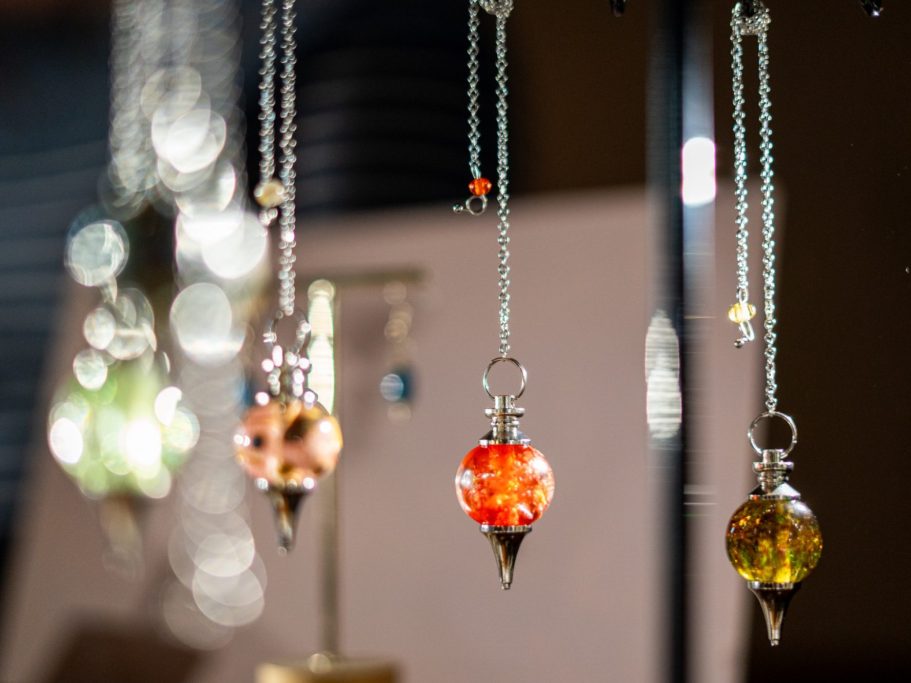Pendants colorés suspendus à des chaînes, avec des reflets brillants.