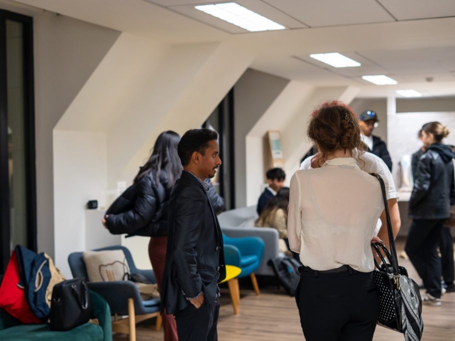 Groupe de personnes discutant dans un espace de bureau moderne.