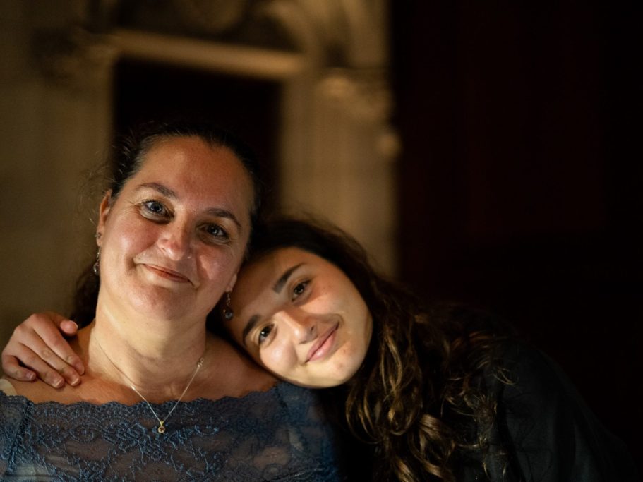 Femme souriante avec une adolescente, posant ensemble dans une ambiance chaleureuse.