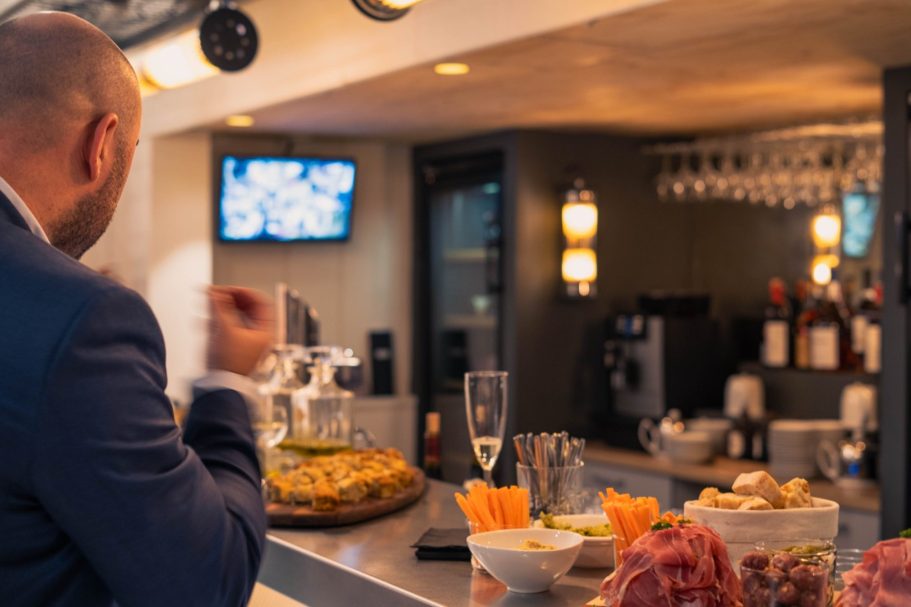 Femme souriante avec des cheveux ondulés, portant un débardeur, en arrière-plan verdoyant.