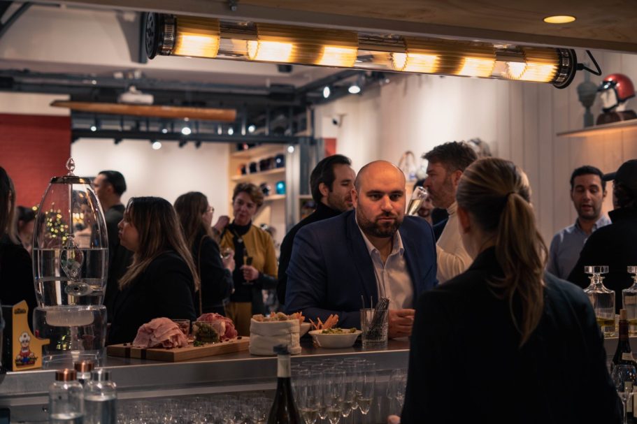 Jeune femme souriante avec des fleurs colorées sur une robe, en arrière-plan flou.