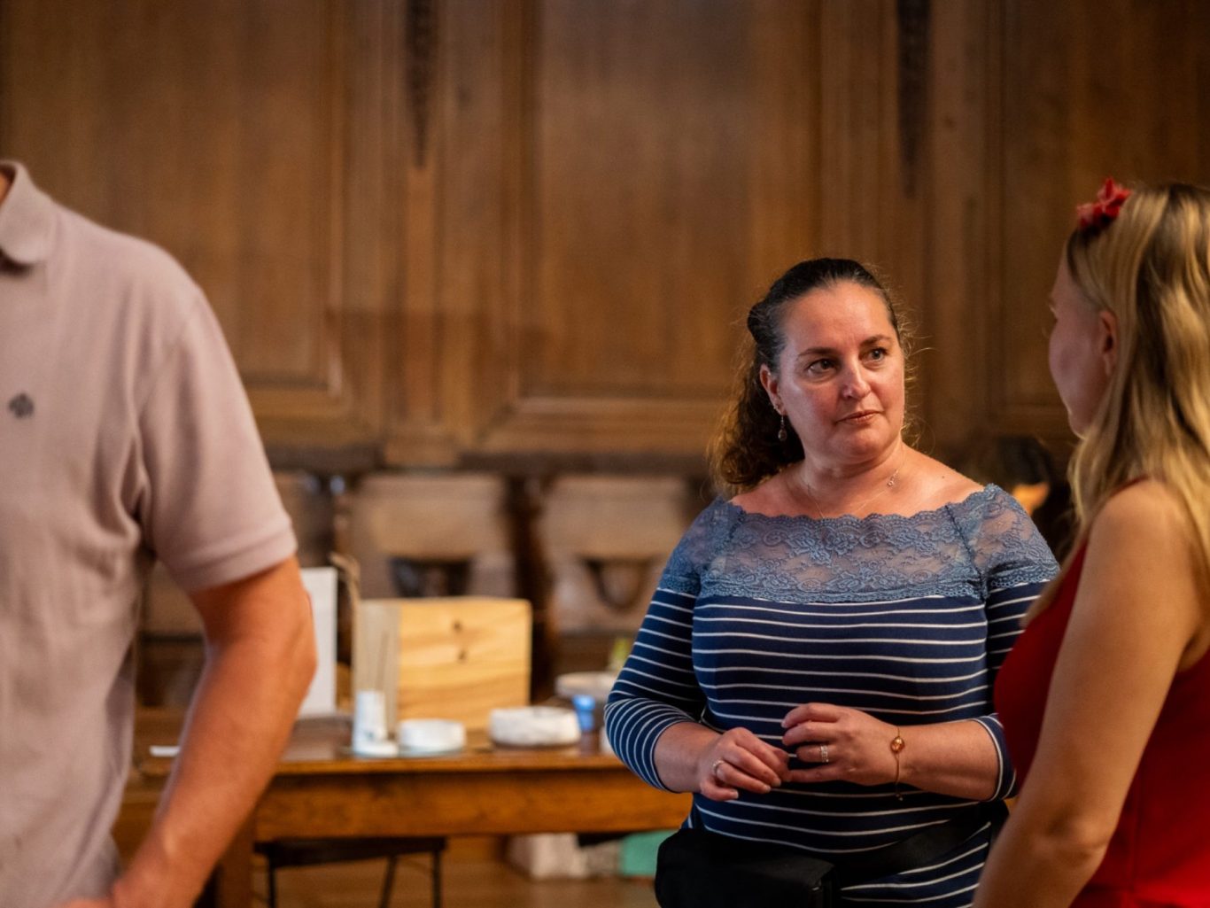 Deux femmes discutent dans un environnement chaleureux avec des meubles en bois.