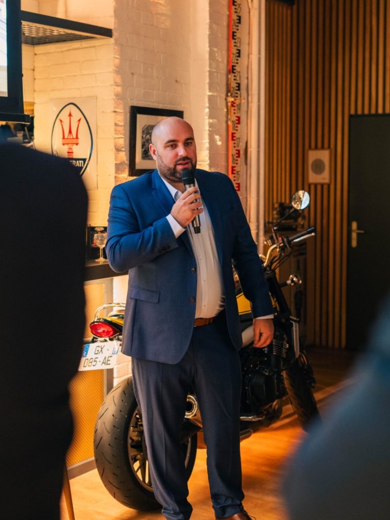 Person assise, vêtue d'une chemise colorée, avec une bouteille d'eau à côté d'elle.