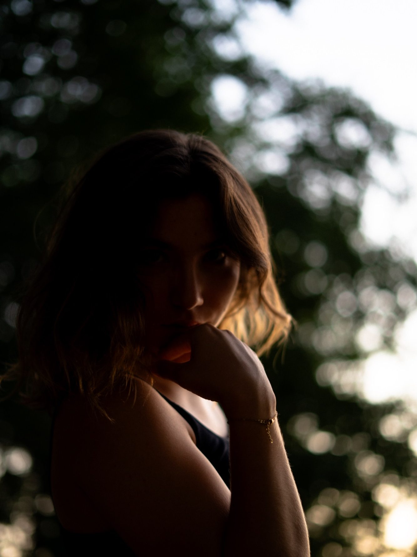 Silhouette d'une femme avec des arbres en arrière-plan lors d'un coucher de soleil.