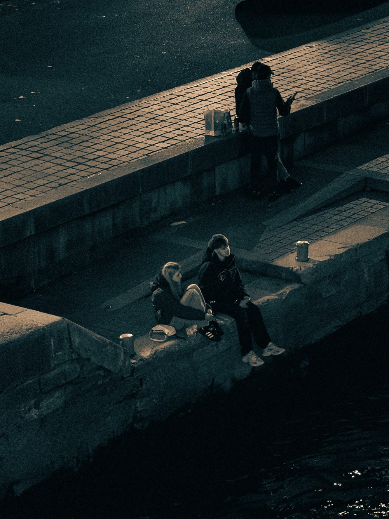 Deux personnes assises au bord de l'eau, discutant et profitant de l'environnement.
