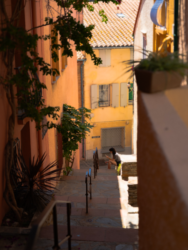 Rue étroite avec des murs colorés et une personne qui s'active en bas.