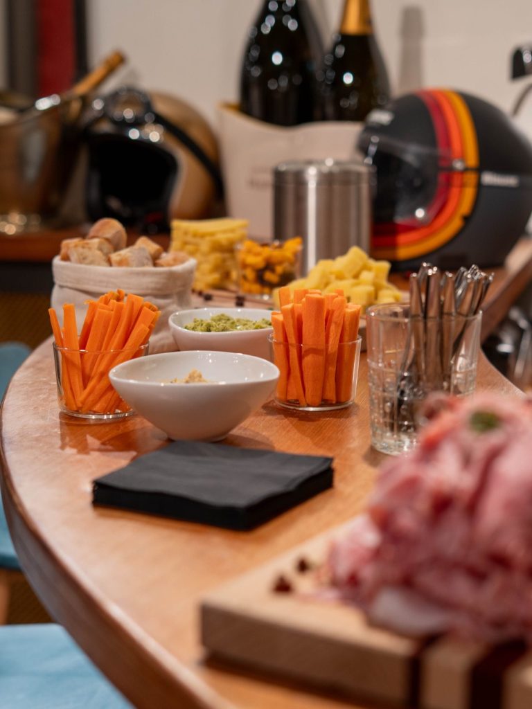 Femme souriante en robe blanche, posant devant un paysage naturel flou.