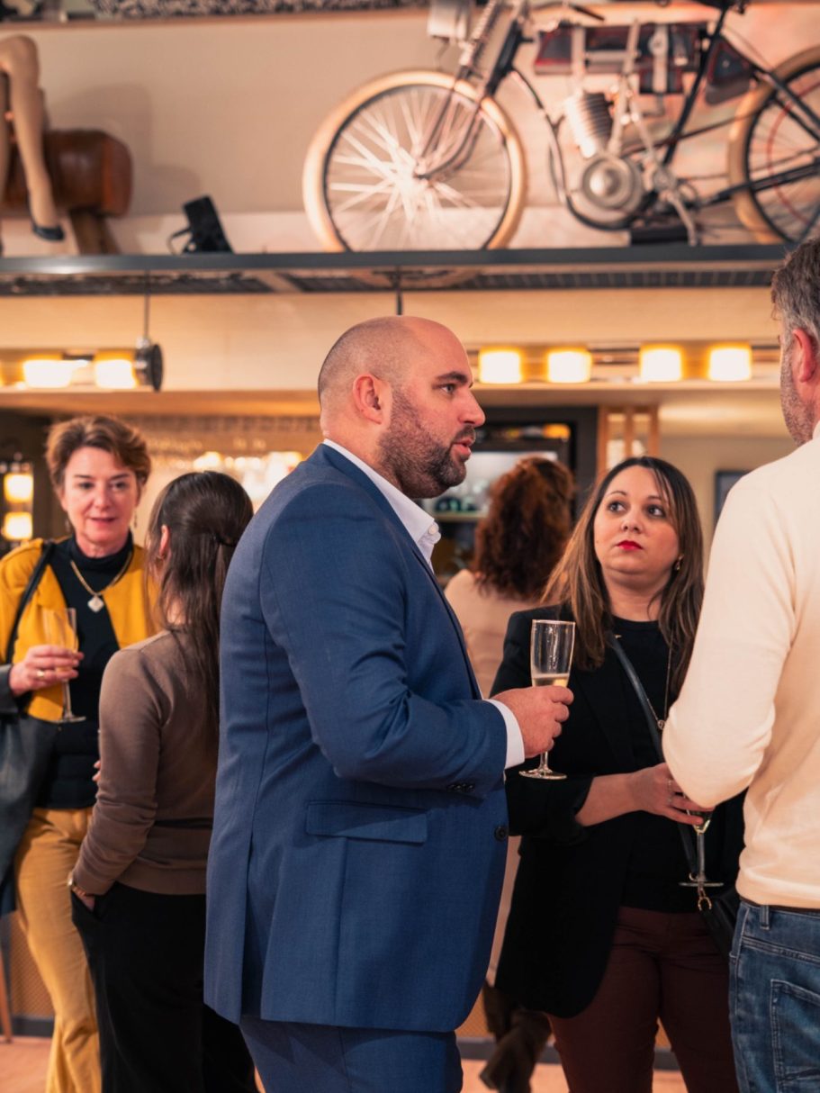 Femme souriante avec les cheveux ébouriffés, posant près d'un lac en arrière-plan.