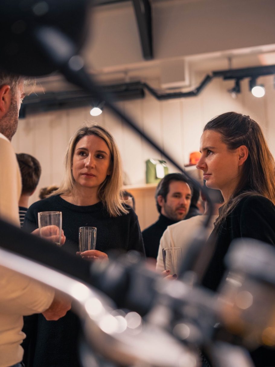 Femme avec des lunettes, cheveux attachés, contemplant un paysage verdoyant.